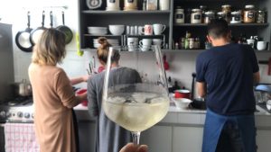 Anfitriones en cocina copa de vino blanco